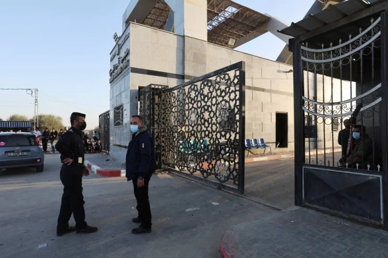 Men stand near a gate as people gather at Rafah border as Hamas militants are expected to release hostages abducted by Hamas during the October 7 attack on Israel as part of a hostages-prisoners swap deal between Hamas and Israel, as seen from southern Gaza Strip Friday. REUTERS