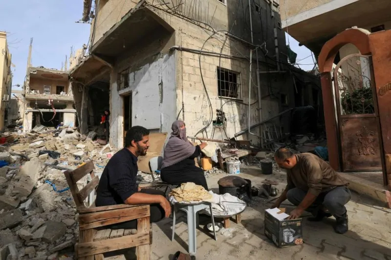 A Palestinian woman bakes traditional bread outside her damaged home in the Khezaa district on the outskirts of the southern Gaza Strip city of Khan Yunis, following weeks of Israeli bombardment, as a truce between Israel and Hamas entered its second day, on Saturday. AFP