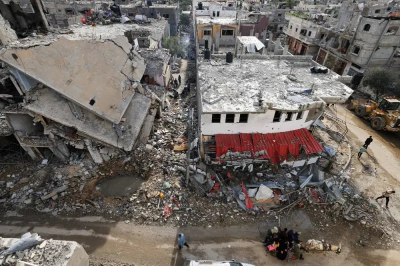 Palestinians walk amid the rubble of destroyed buildings in the Khezaa district on the outskirts of the southern Gaza Strip city of Khan Yunis, following weeks of Israeli bombardment, as a truce between Israel and Hamas entered its second day, on Saturday. AFP
