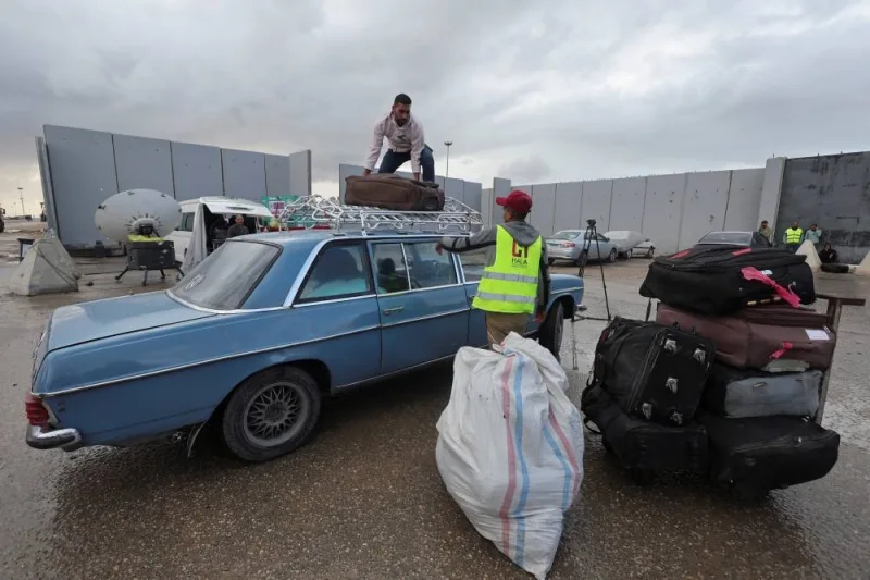 Egyptian workers handle the luggage of Palestinians who are returning to Gaza, at the Rafah border crossing between Egypt and the Gaza Strip, during a temporary truce between Hamas and Israel, in Rafah, Egypt, Monday. REUTERS