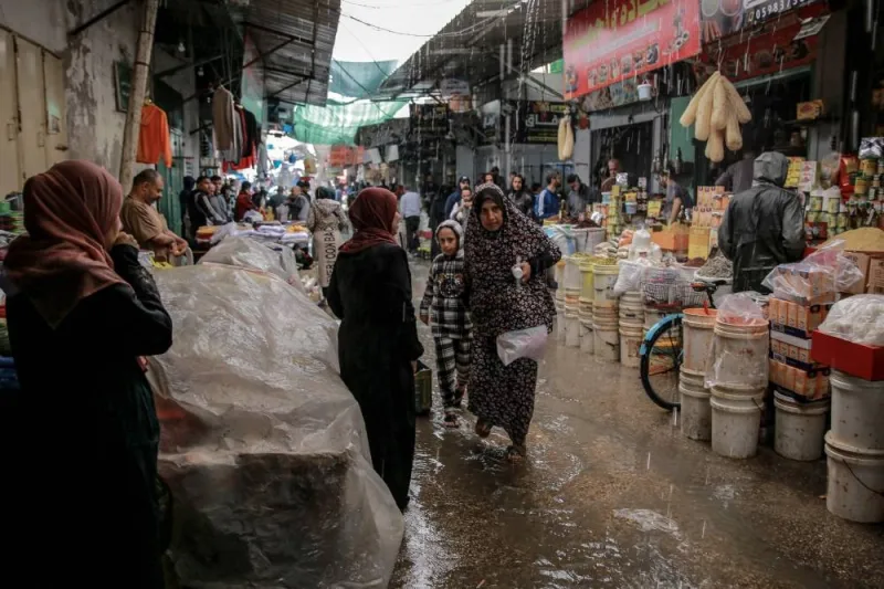 Palestinians shop amid rain in Al-Zawiya market in Gaza City on Monday, on the fourth day of a truce in fighting between Israel and Hamas. AFP