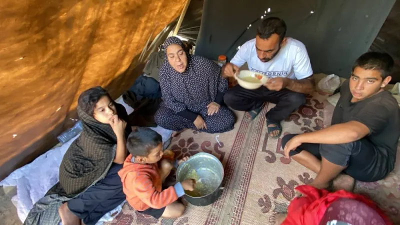 Watan al-Masri and his displaced family, who fled their houses due to Israeli strikes, have lentil soup, inside their tent at Nasser hospital in Khan Younis in the southern Gaza Strip, on Friday. REUTERS