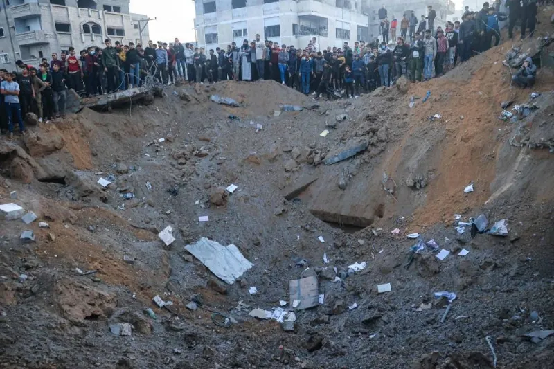 Palestinians stand on the edge of a crater after an Israeli strike in Rafah in the southern Gaza Strip on Sunday. AFP
