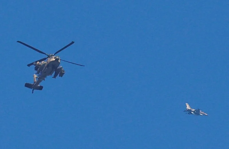 An Israeli military Apache helicopter and a jet fly close to the Gaza strip, on Sunday. REUTERS