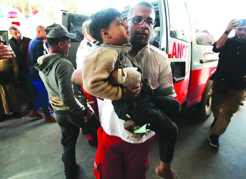 
A member of ‘Palestine Red Crescent Society’ assists a Palestinian child as wounded Palestinians are rushed into Nasser hospital following Israeli strikes, amid the ongoing conflict, in Khan Yunis, in the 
southern Gaza Strip, yesterday. 