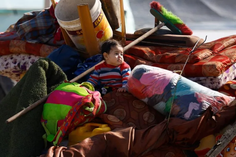 A baby sits on a pile of things, as displaced Palestinians, who fled their houses due to Israeli strike, shelter in a camp in Rafah, in the southern Gaza Strip, Wednesday. REUTERS