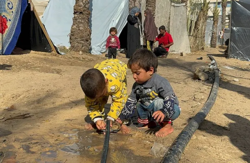 Palestinian children get water from a pipe, as displaced Palestinians who fled their houses due to Israeli strikes, shelter in a tent camp, in Khan Younis in the southern Gaza Strip, on Friday. REUTERS