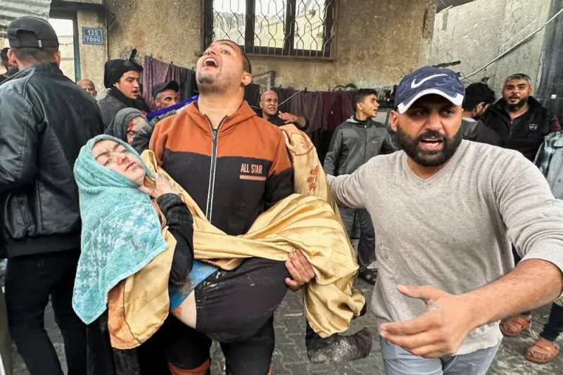 People carry an injured person following an Israeli air strike on Palestinian houses, in Rafah in the southern Gaza Strip, on Tuesday. REUTERS