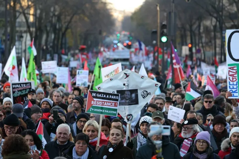 Protesters hold placards and flags during a rally calling for a permanent ceasefire in war between Israel and Hamas in Gaza, in Paris, on Sunday. AFP
