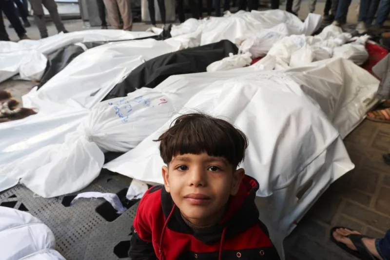 A boy looks on next to the bodies of Palestinians killed in Israeli strikes at a hospital in Rafah, in the southern Gaza Strip, on Tuesday. REUTERS