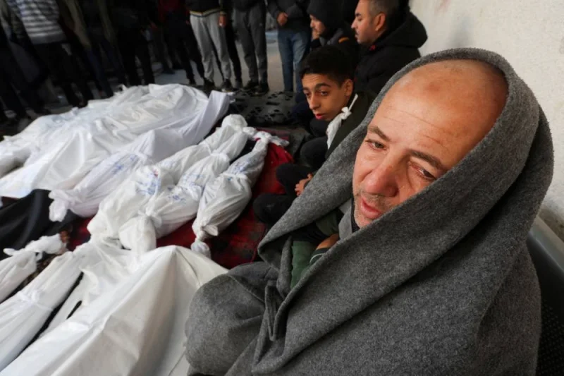 Mourners sit next to the bodies of Palestinians killed in Israeli strikes at a hospital in Rafah, in the southern Gaza Strip, on Tuesday. REUTERS