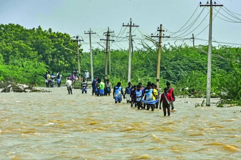 People wade through a flooded road after heavy rains in Thoothukudi, Tamil Nadu, India, on Wednesday.