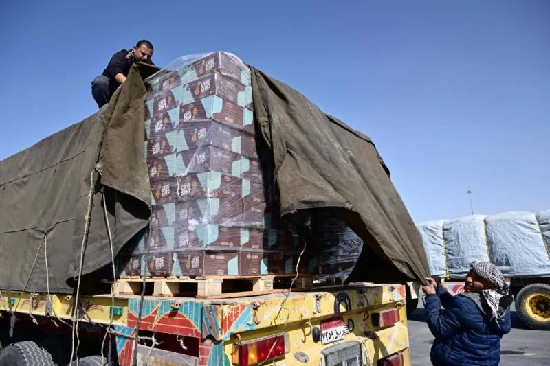 A truck driver refastens his humanitarian aid cargo after inspection by Israeli security upon arriving from Egypt on the Israeli side of the Kerem Shalom border crossing with the southern Gaza Strip on Friday. AFP