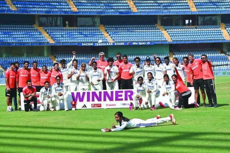 
India’s players pose with the trophy after winning the Test match against Australia at the Wankhede Stadium in Mumbai yesterday. India’s women’s cricket team cruised to their first-ever win against Australia in Test cricket, beating the visitors by eight wickets in a one-off match. (AFP) 
