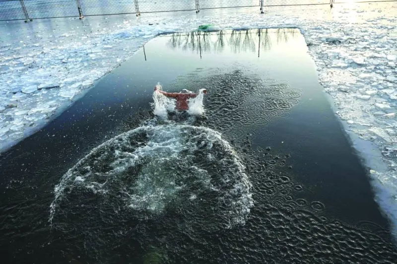 A man swims in a partly frozen lake in Beijing.