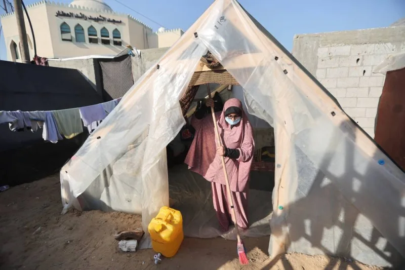 Abeer, a deaf woman, who with her family fled their house due to Israeli strikes, holds a brush as she takes shelter in a tent camp, in Rafah in the southern Gaza Strip, on Tuesday. REUTERS