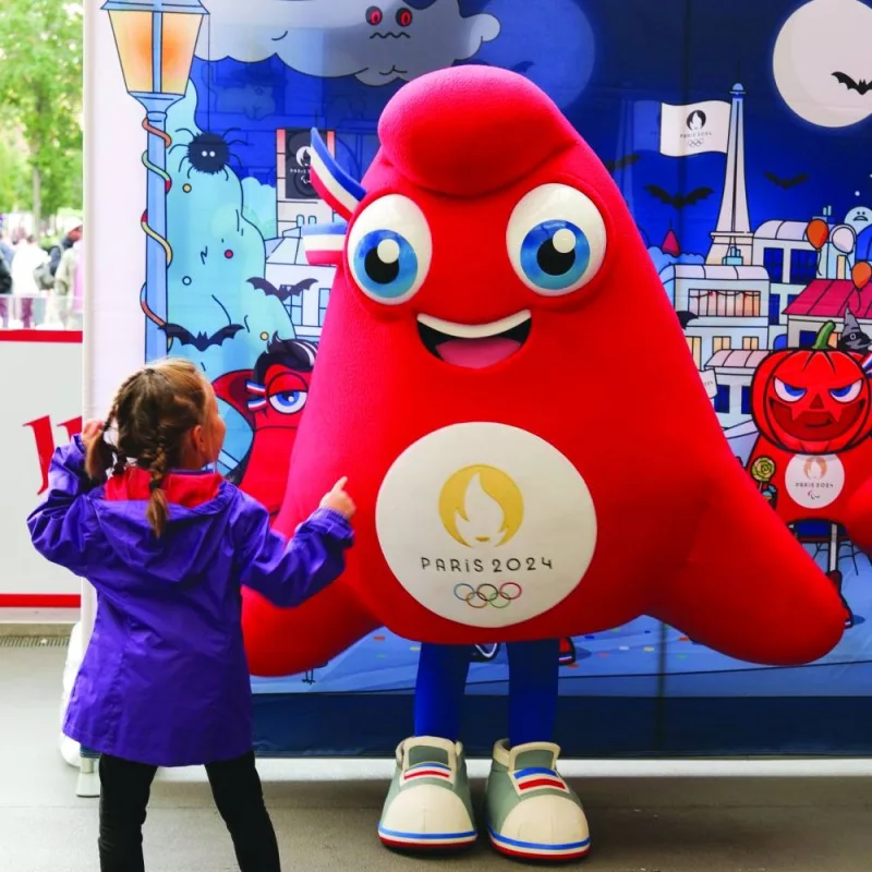
A young girl greets the Paris Olympics mascot.
 