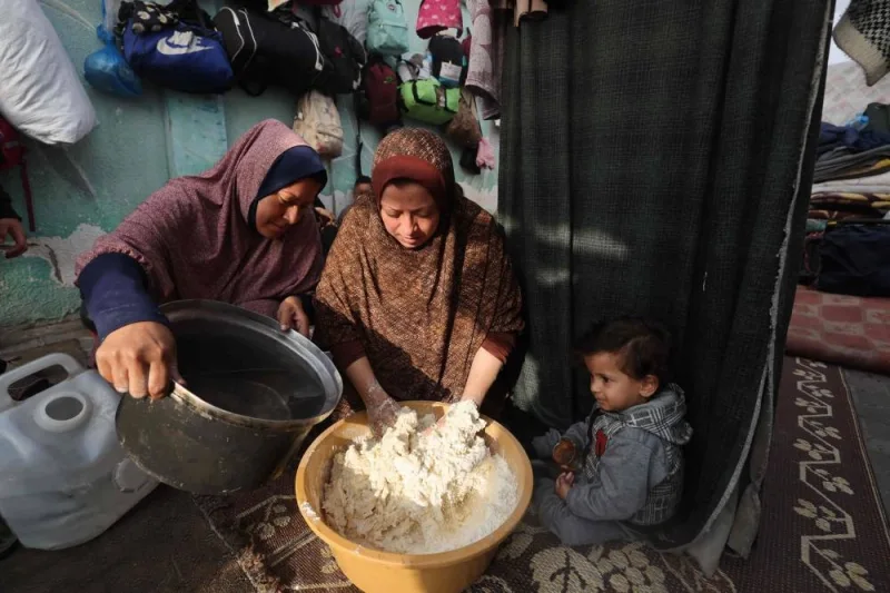 Displaced Palestinian women prepare bread inside a tent in Rafah in the southern Gaza Strip, on Wednesday. AFP