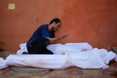 Palestinian man Mohammed al-Akhras reacts next to the bodies of his daughter Jana and his wife who were killed by Israeli strikes in Khan Younis in the southern Gaza Strip, on Tuesday. REUTERS