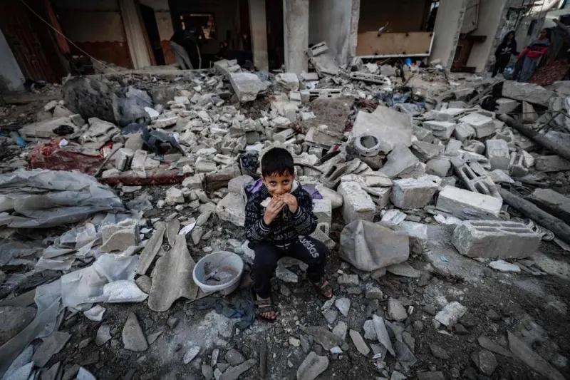  A child eats amid the rubble of destroyed buildings following Israeli bombardment in Rafah on the southern Gaza Strip on Saturday. AFP
