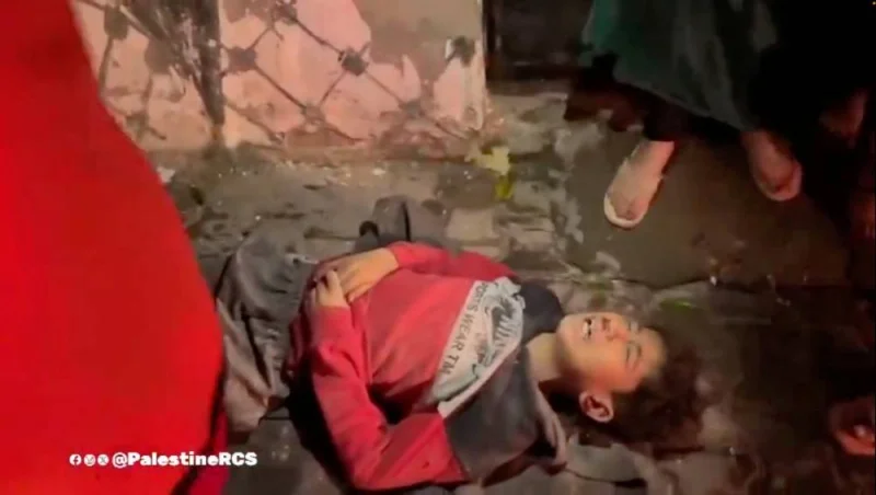 A child reacts as he lies on the ground following what the Palestine Red Crescent Society says was an Israeli shelling in a location given as Nuseirat camp, Deir Al-Balah, Gaza, in this screengrab taken from a handout video released on Saturday. Palestine Red Crescent Society/Handout via REUTERS 