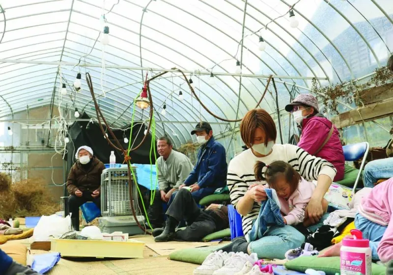 
Residents shelter inside a plastic greenhouse after being evacuated in the city of Wajima. 