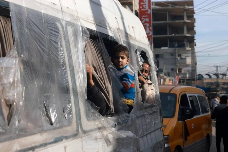 Palestinians look from the windows of a minibus at a market in Rafah refugee camp in the Gaza Strip on Monday. AFP