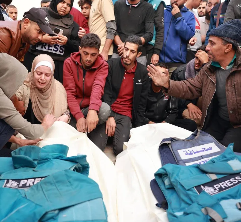 Relatives and colleagues of two Palestinian journalists Hassouneh Salim and Sari Mansour, killed in an Israeli airstrike, mourn over their bodies during their funeral in Deir al-Balah in the southern Gaza Strip on November 19.  (Photo: AFP/Bashar Taleb)