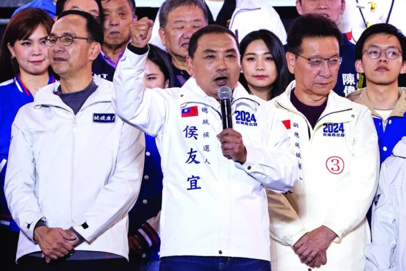 Taiwan's presidential candidate of the Kuomintang (KMT) opposition party, Hou Yu-ih (centre) speaks next to his running mate Jaw Shaw-kong (right) during an election campaign rally in New Taipei City.