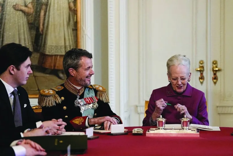 Queen Margrethe II of Denmark signs the declaration of abdication as her son Crown Prince Frederik becomes king and her grandson Prince Christian watches in the Council of State. 