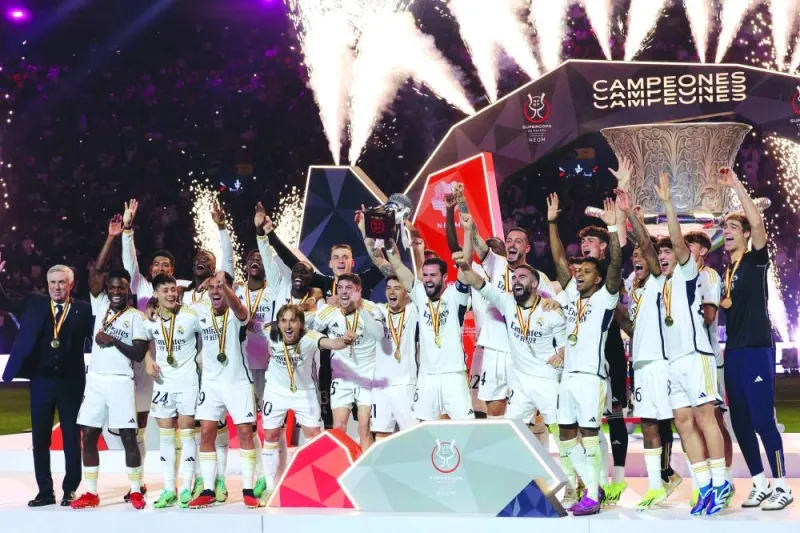 
Real Madrid’s defender and captain Nacho Fernandez lifts the trophy as he celebrates with his teammates after winning the Spanish Super Cup final against Barcelona at Al-Awwal Park Stadium in Riyadh. (AFP) 