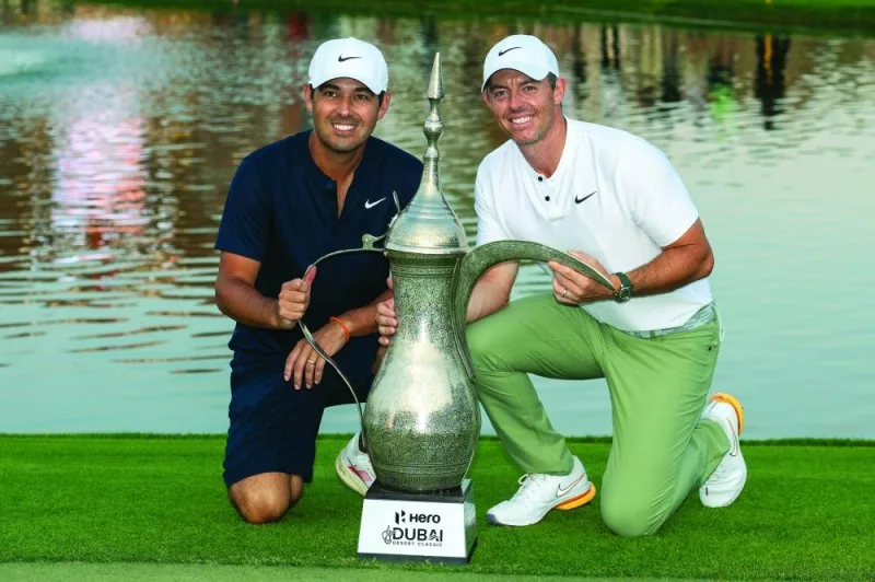 
Rory McIlroy of Northern Ireland poses with his caddy Harry Diamond (left) next to his trophy after winning the Hero Dubai Desert Classic on the Majlis Course at the Emirates Golf Club in Dubai yesterday. McIlroy won a record fourth Dubai Desert Classic title by one shot. (AFP) 