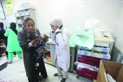 
A Palestinian woman holds a child wounded in an Israeli strike at Nasser Hospital, amid the ongoing conflict, in Khan Yunis in the southern Gaza Strip. 