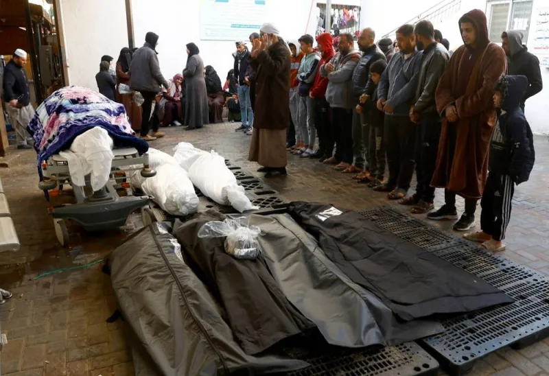 People pray next to dead bodies, including those of Palestinians killed in Israeli strikes in Khan Younis, after they were brought into al-Najjar hospital, in Rafah in the southern Gaza Strip, on Wednesday. REUTERS