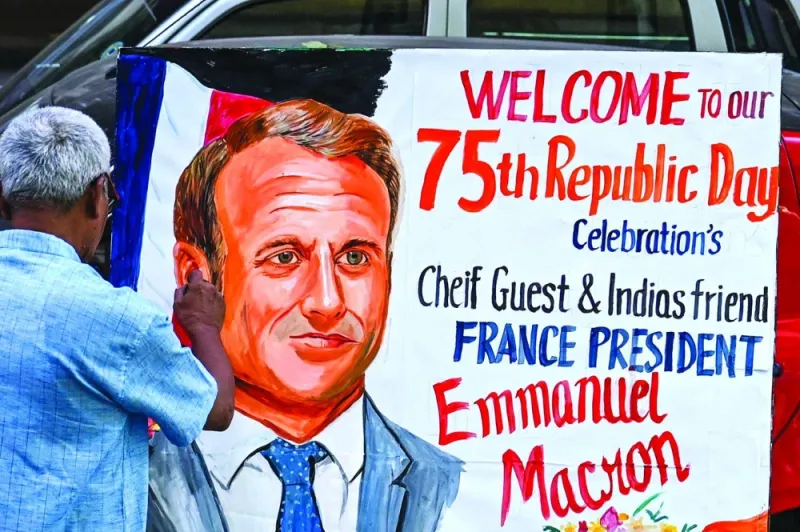An artist gives finishing touches to a painting of French President Emmanuel Macron outside an art school in Mumbai.