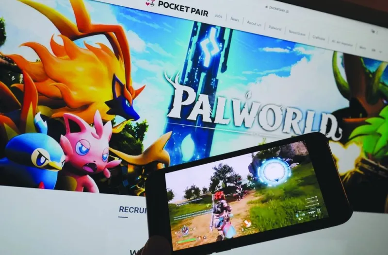 
This illustration photo shows the trailer for the game Palworld being played on a smartphone in front of a screen showing the PocketPair website. 