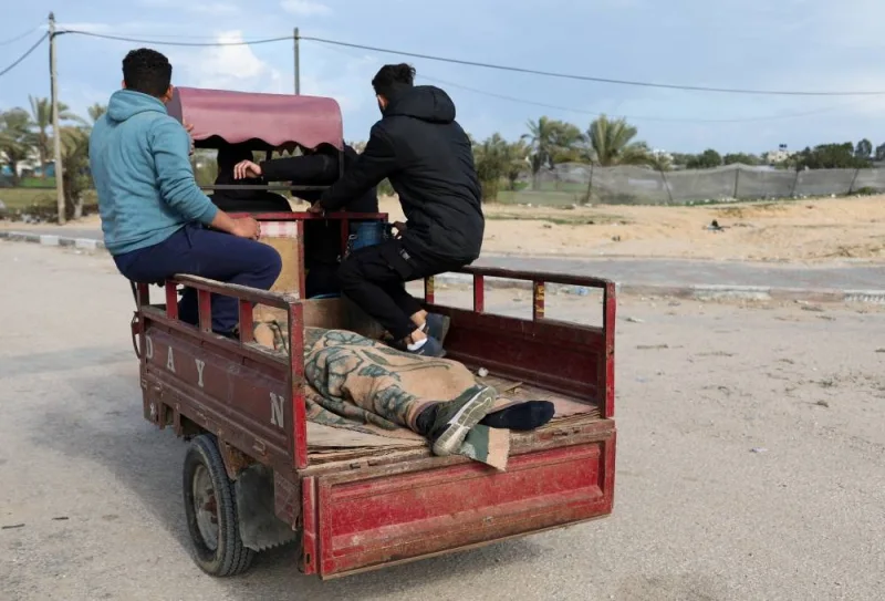 The body of a Palestinian killed in an Israeli strike lies in the back of a vehicle, as Palestinians fleeing Khan Younis, due to the Israeli ground operation, move towards Rafah, in the southern Gaza Strip, on Sunday. REUTERS