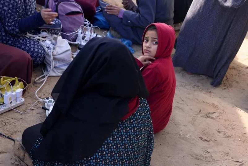 A girl waits to charge a mobile phone as displaced Palestinians, who fled their houses due to Israeli strikes, shelter at a tent camp in Rafah in the southern Gaza Strip, on Sunday. REUTERS
