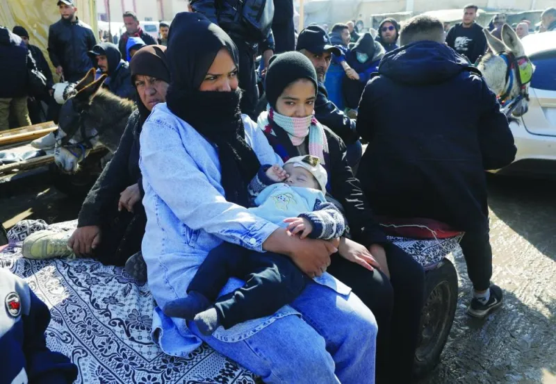 A woman holds a baby as displaced Palestinians, who fled their houses due to Israeli strikes, shelter at a tent camp, amid the ongoing conflict, in Rafah in the southern Gaza Strip, yesterday.