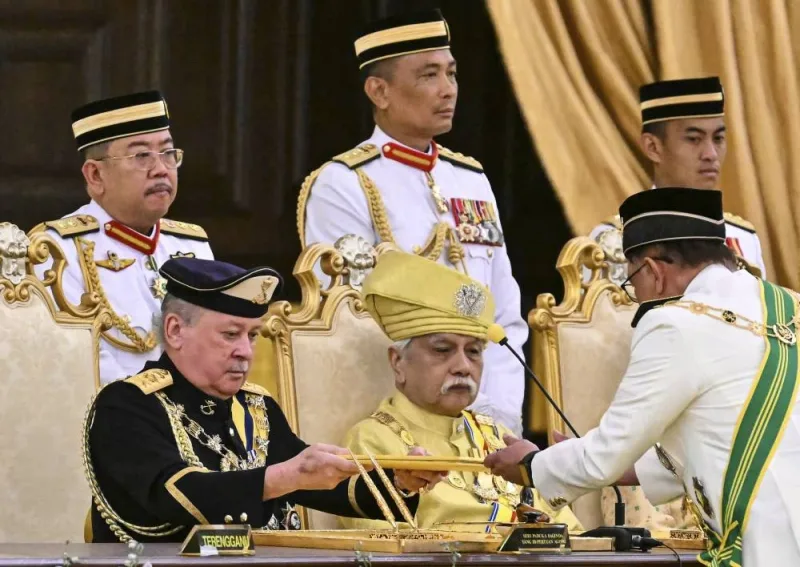 Sultan of Johor, Sultan Ibrahim Iskandar, left, receives documents from Malaysia's Prime Minister Anwar Ibrahim during the oath taking ceremony as the 17th King of Malaysia at the National Palace in Kuala Lumpur on Wednesday, Jan. 31, 2024. Sultan Ibrahim, the powerful billionaire ruler of southern Johor state, was sworn-in Wednesday as Malaysia’s new king. (Mohd Rasfan/Pool Photo via AP)