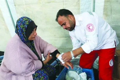 
A medic helps a Palestinian woman at a medical point, formed to get better access to frontlines, amid the ongoing conflict, in Khan Younis in the southern Gaza Strip. 