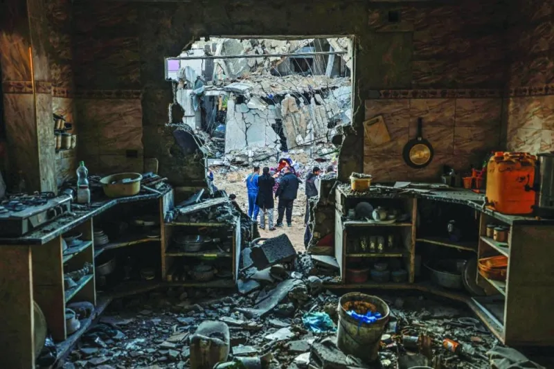 People check the damage following Israeli bombardment in Rafah Saturday.