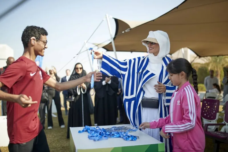 HH Sheikha Moza awarding a participant in an event