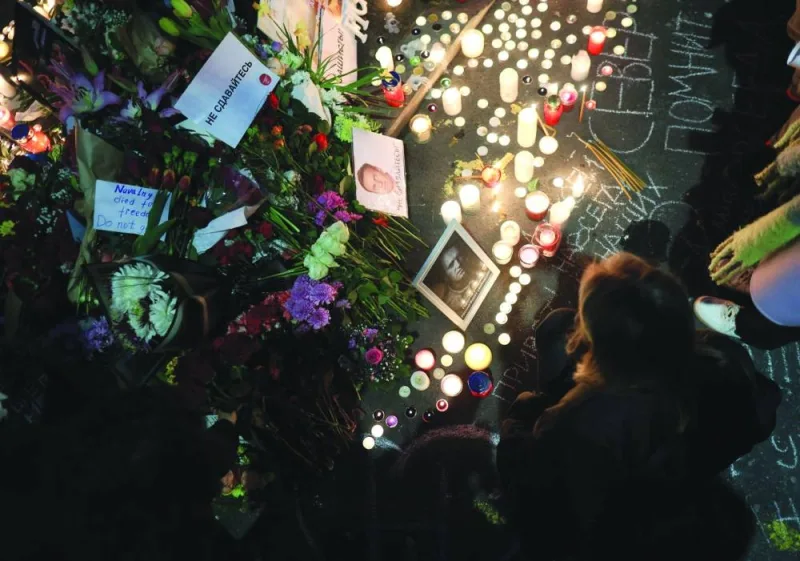 
Protesters stand before lit candles as they pay their respects outside the Russian embassy in Belgrade. 