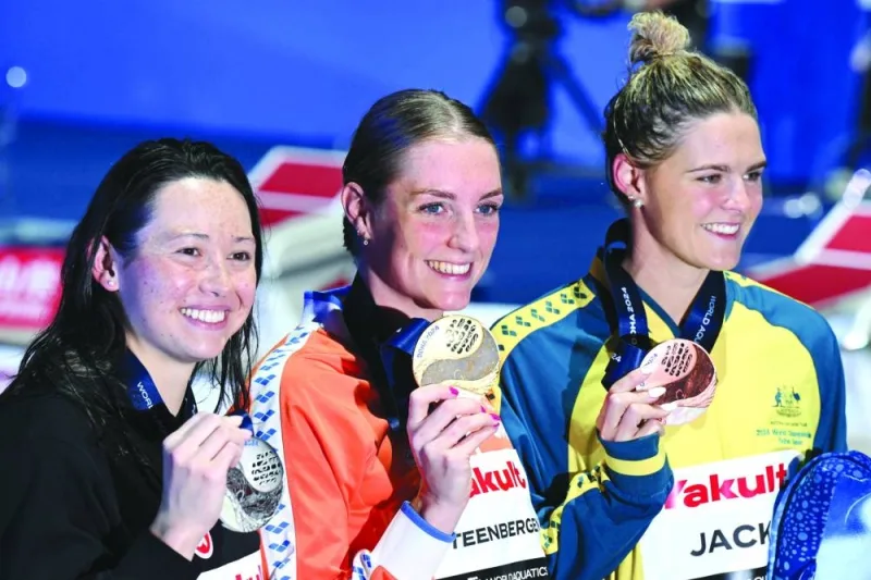 Gold medallist Netherlands’ Marrit Steenbergen (centre), silver medallist Hong Kong’s Siobhan Bernadette Haughey (left) and bronze medallist Australia’s Shayna Jack pose on the podium of the women’s 100m freestyle event during the 2024 World Aquatics Championships at Aspire Dome in Doha on Friday. (AFP)