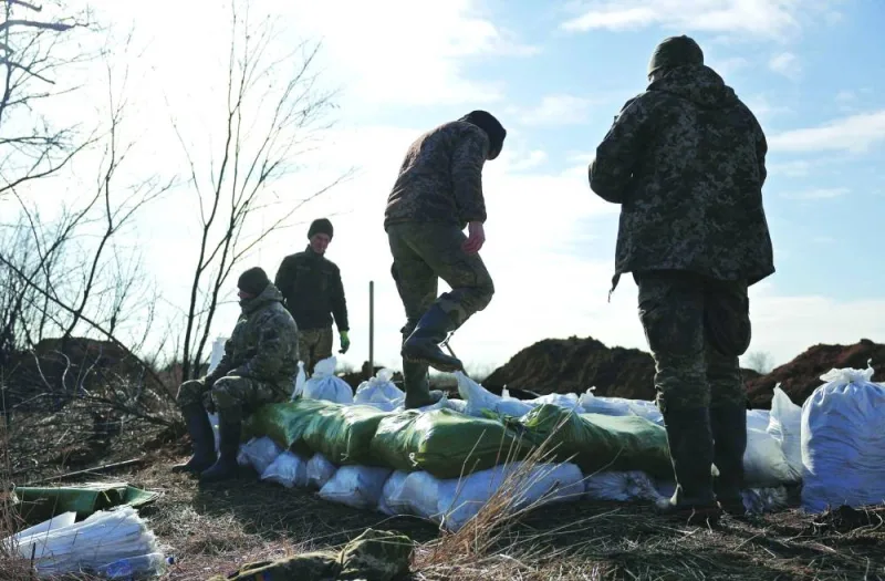 Ukrainian servicemen pile up earthbags to build a fortification not far from the town of Avdiivka in the Donetsk region on Saturday. (AFP)