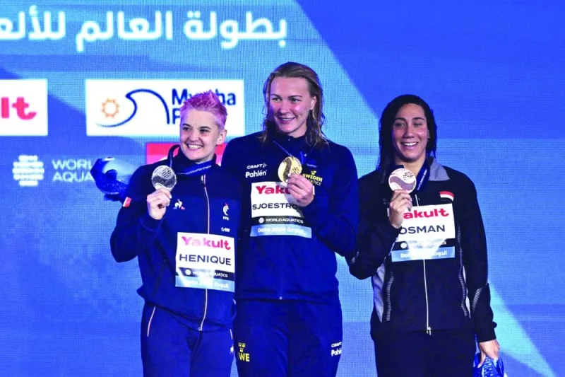 Gold medallist Sweden’s Sarah Sjostrom (centre), silver medallist France’s Melanie Henique (left) and bronze medallist Egypt’s Farida Osman pose on the podium of the women’s 50m butterfly event on Saturday. (AFP)