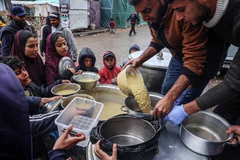 Volunteers distribute rations of red lentil soup to displaced Palestinians in Rafah in the southern Gaza Strip on Sunday. AFP