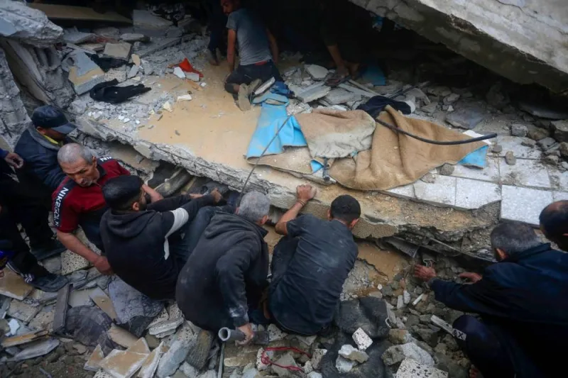People search for victims in the rubble of a house in Deir al-Balah in the central Gaza Strip after it was hit in an Israeli air strike Sunday.