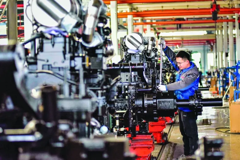 
An employee works on a tractor production line at a factory in Weifang, in China’s eastern Shandong province. China’s manufacturing activity in February shrank for a fifth straight month, an official survey showed yesterday, raising pressure on Beijing to roll out more stimulus measures as the parliament prepares for a key annual meeting next week. 